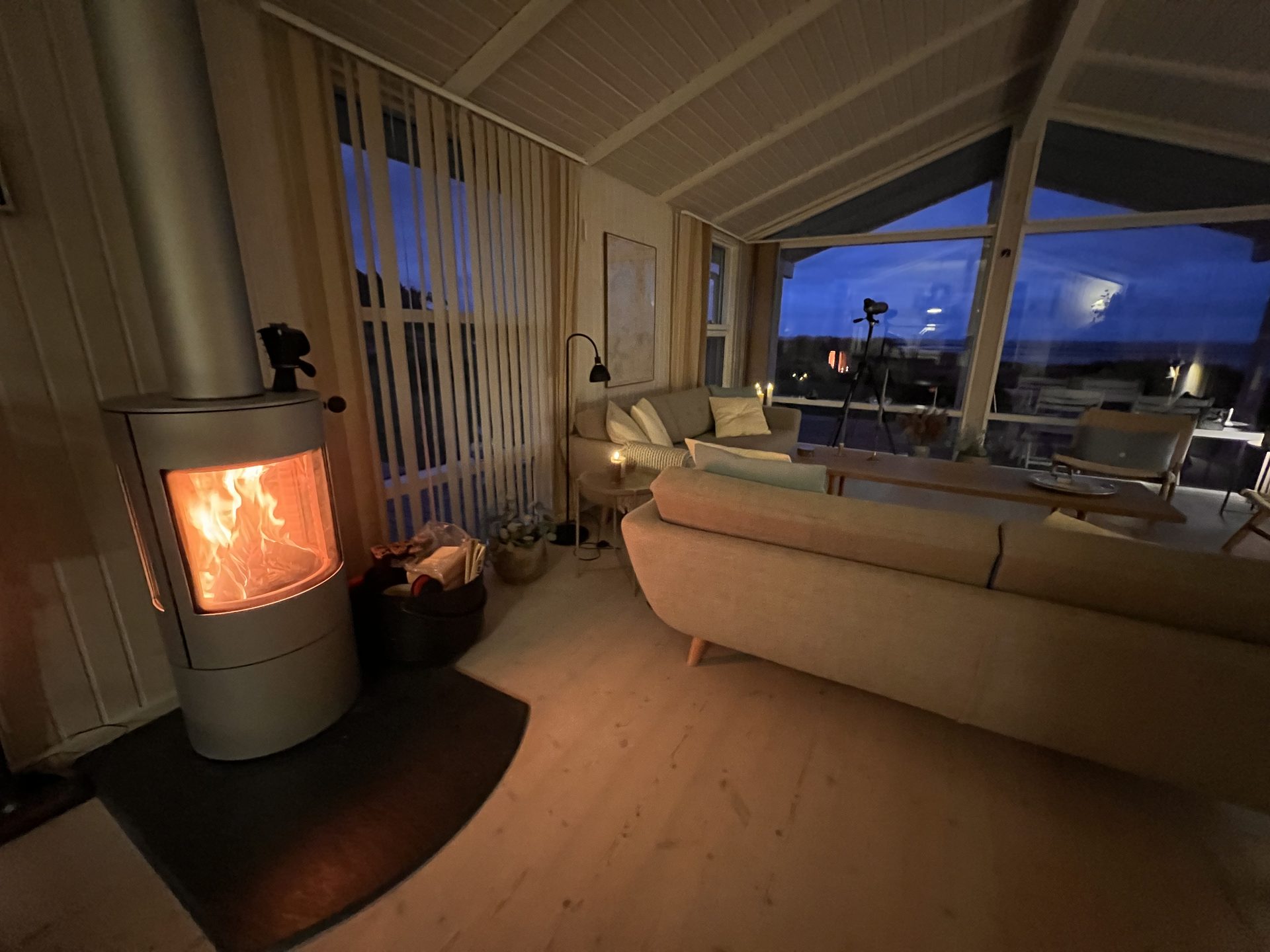 Stue med brændeovn og havudsigt